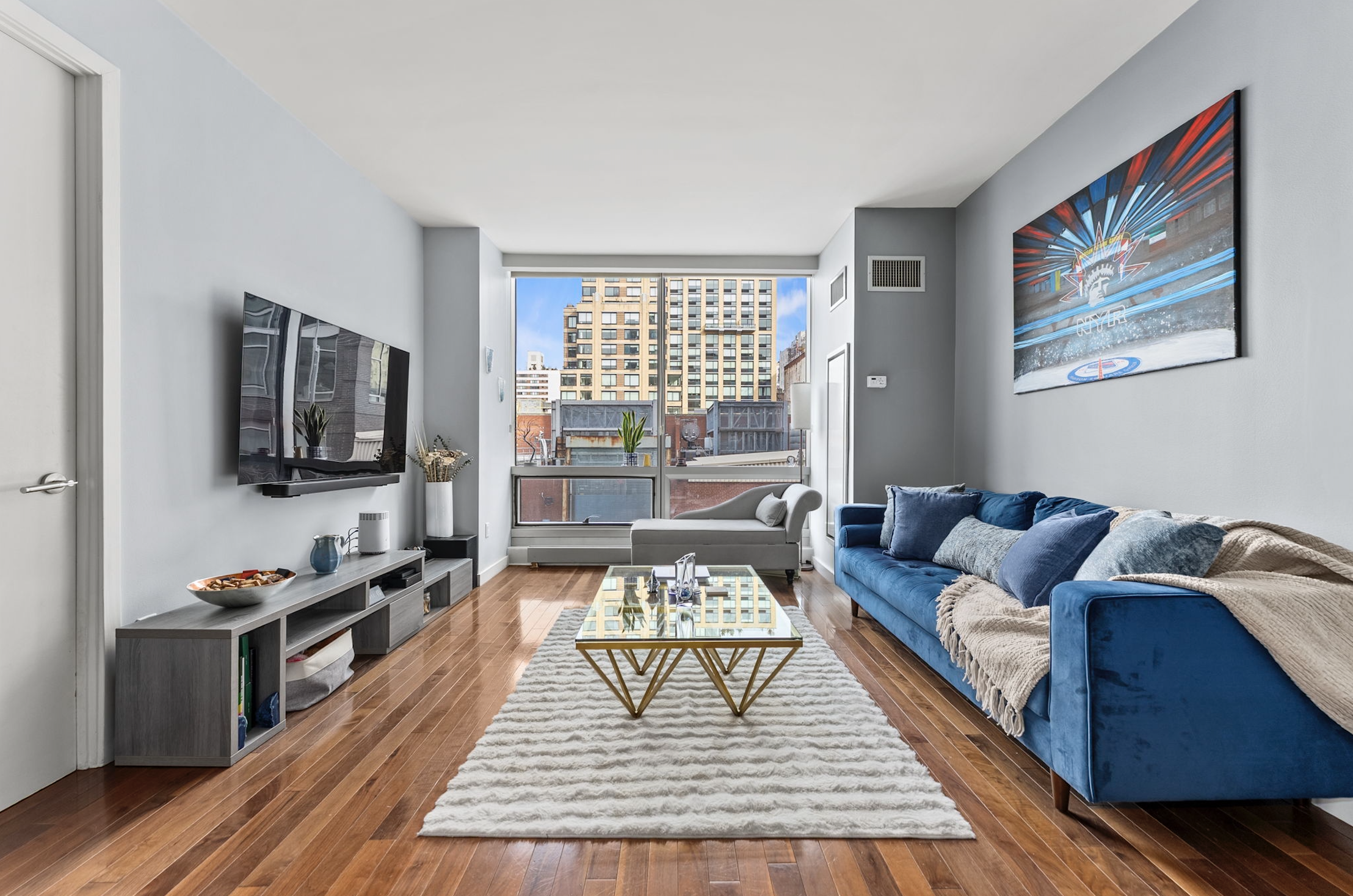166 West 18th Street, Unit 2D Manhattan, NY 10011 - Photo 4 of 17 a living room with furniture and a flat screen tv