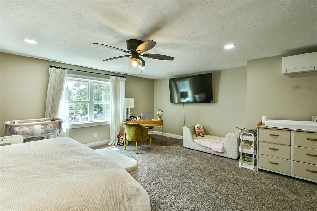 20 Lakeview Road Webster, MA 01570 - Photo 31 of 42 a bedroom with a bed a couch and a flat screen tv