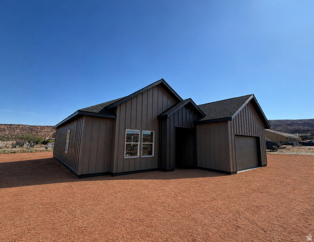 27 Lidia Circle Moab, UT 84532 - Photo 1 of 5 RENDERING. Modern single-story residence with vertical siding, pitched shingle roof, and attached garage.