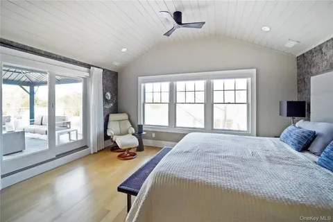 a bedroom with a bed and large windows