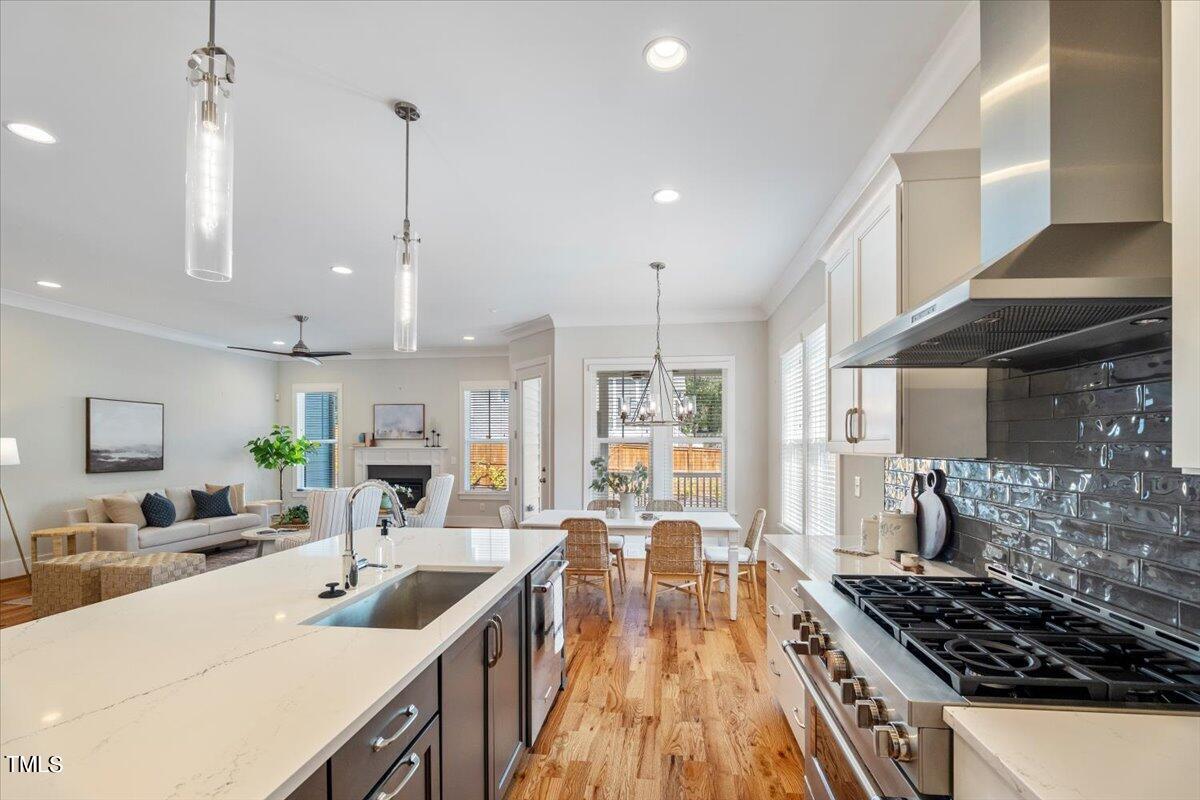 6152 Blanche Drive Raleigh, NC 27607 - Photo 15 of 47 a kitchen with stainless steel appliances a stove a sink a oven a dining table and chairs