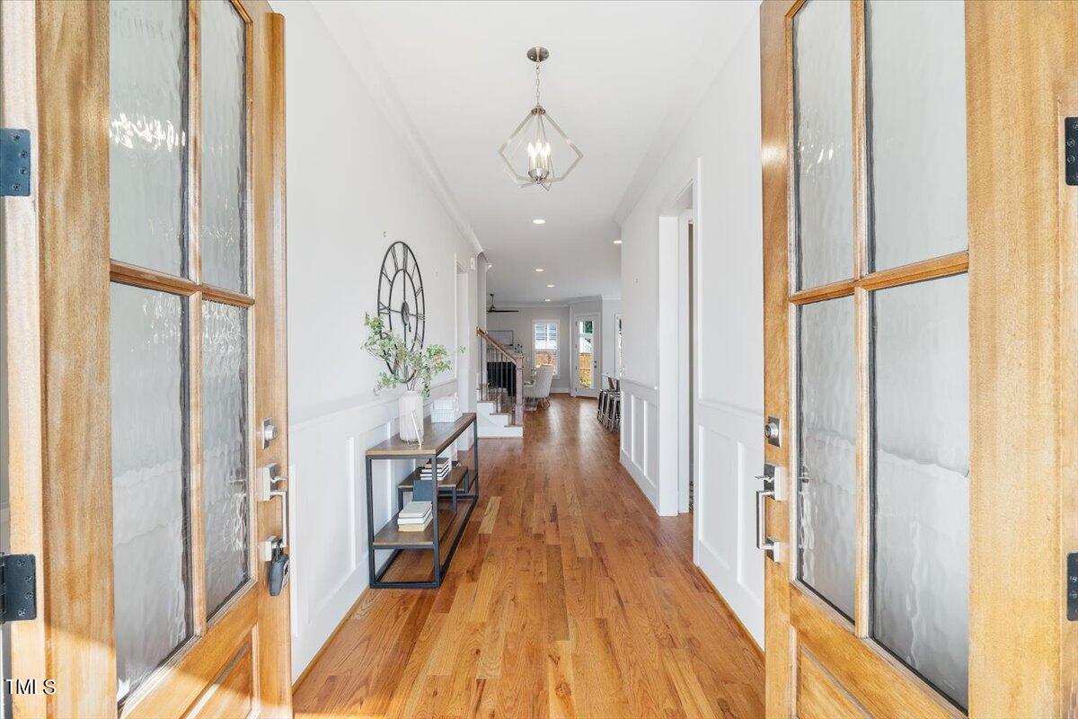 6152 Blanche Drive Raleigh, NC 27607 - Photo 3 of 47 a view of a hallway with wooden floor and furniture