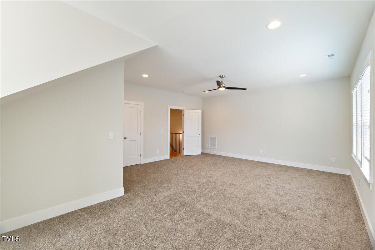 6152 Blanche Drive Raleigh, NC 27607 - Photo 36 of 47 an empty room with an entryway and chandelier fan