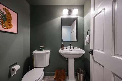 a bathroom with a toilet sink and mirror