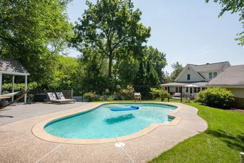 a swimming pool with outdoor seating and yard