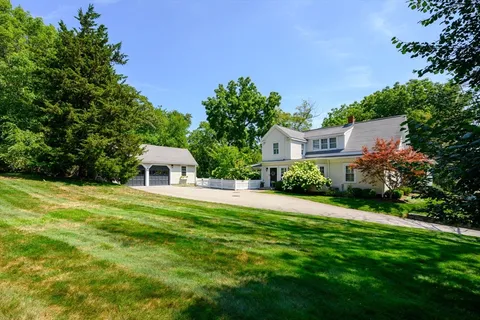 a front view of a house with a yard and trees