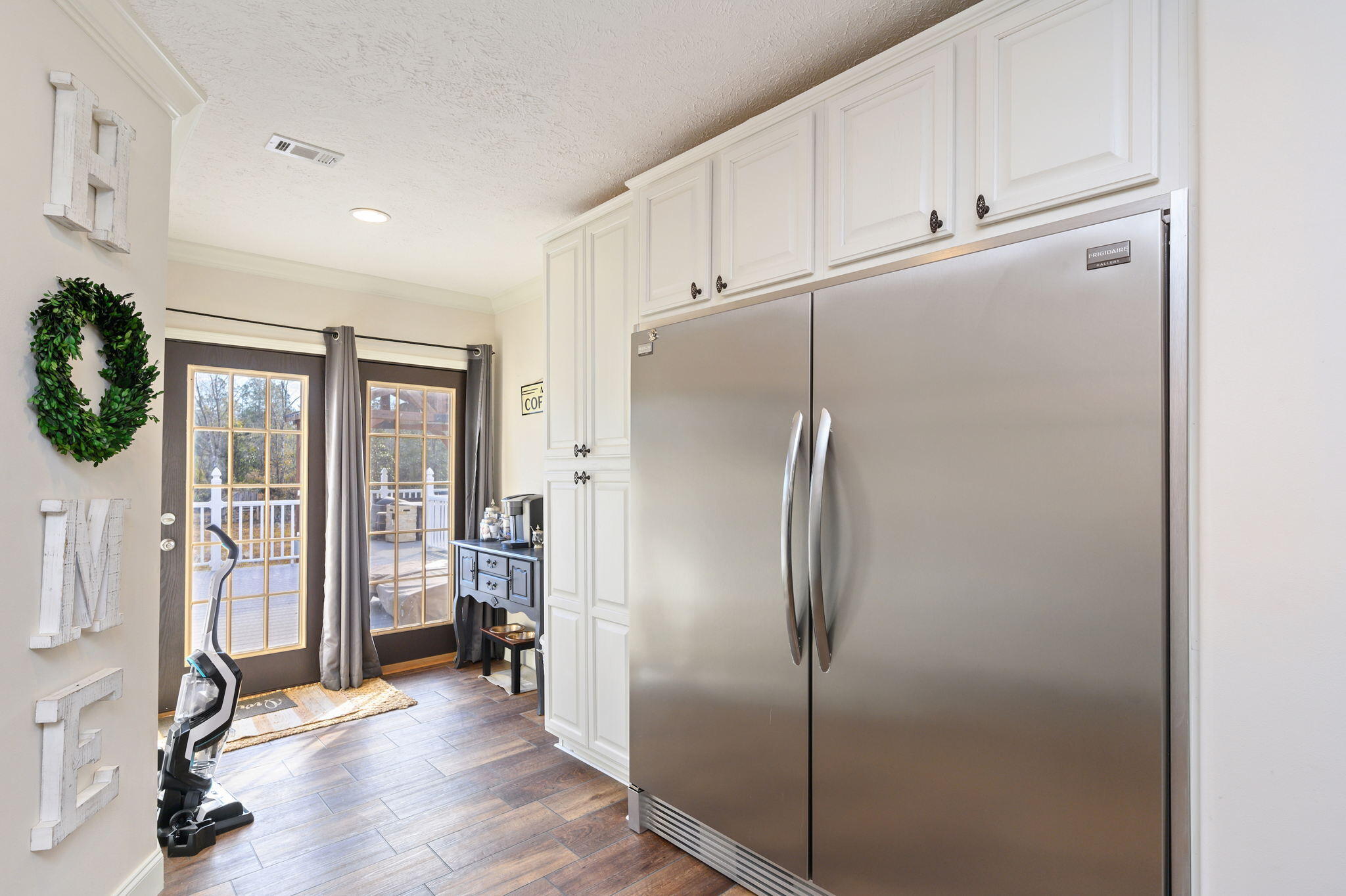 6019 Old River Road Baker, FL 32531 - Photo 17 of 54 a view of a refrigerator in kitchen and an empty room with wooden floor