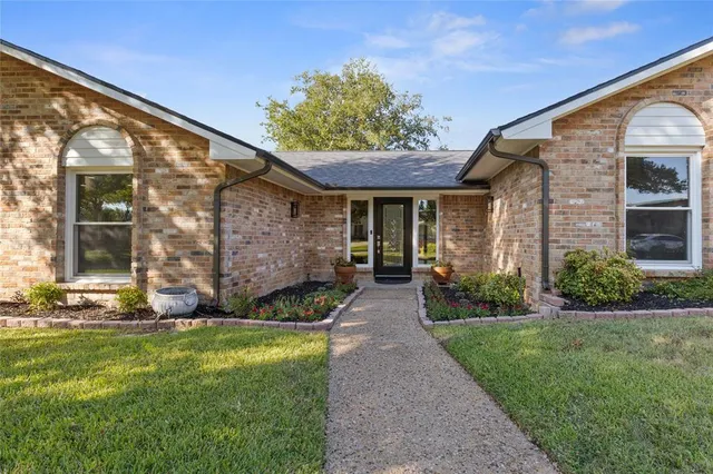 a view of a brick house with a large windows and a yard