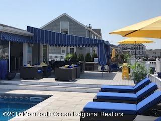 203 Helm Road Mantoloking, NJ 08738 - Photo 12 of 42 a view of a patio with table and chairs potted plants and floor to ceiling window