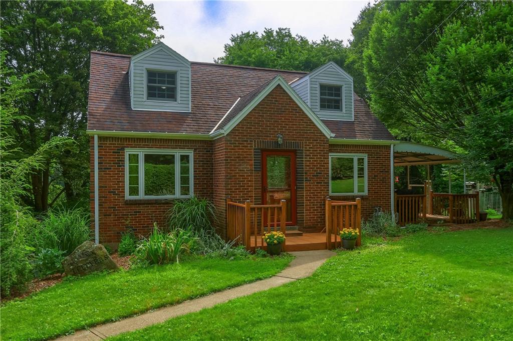 a front view of a house with a yard and green space