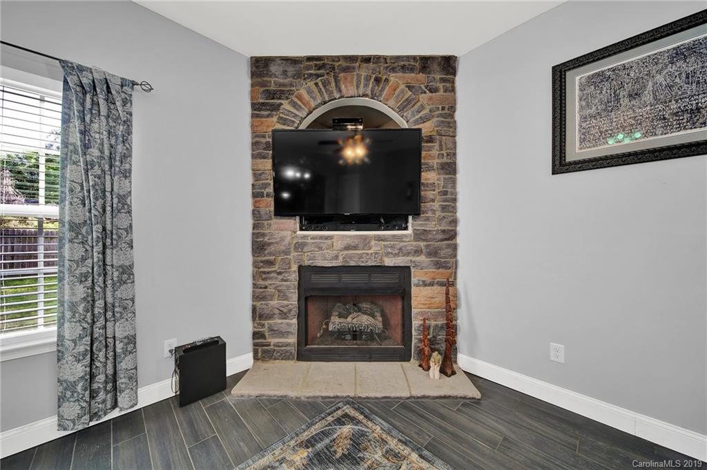 778 Jones Branch Road Fort Mill, SC 29715 - Photo 17 of 44 a living room with a fireplace and a floor to ceiling window