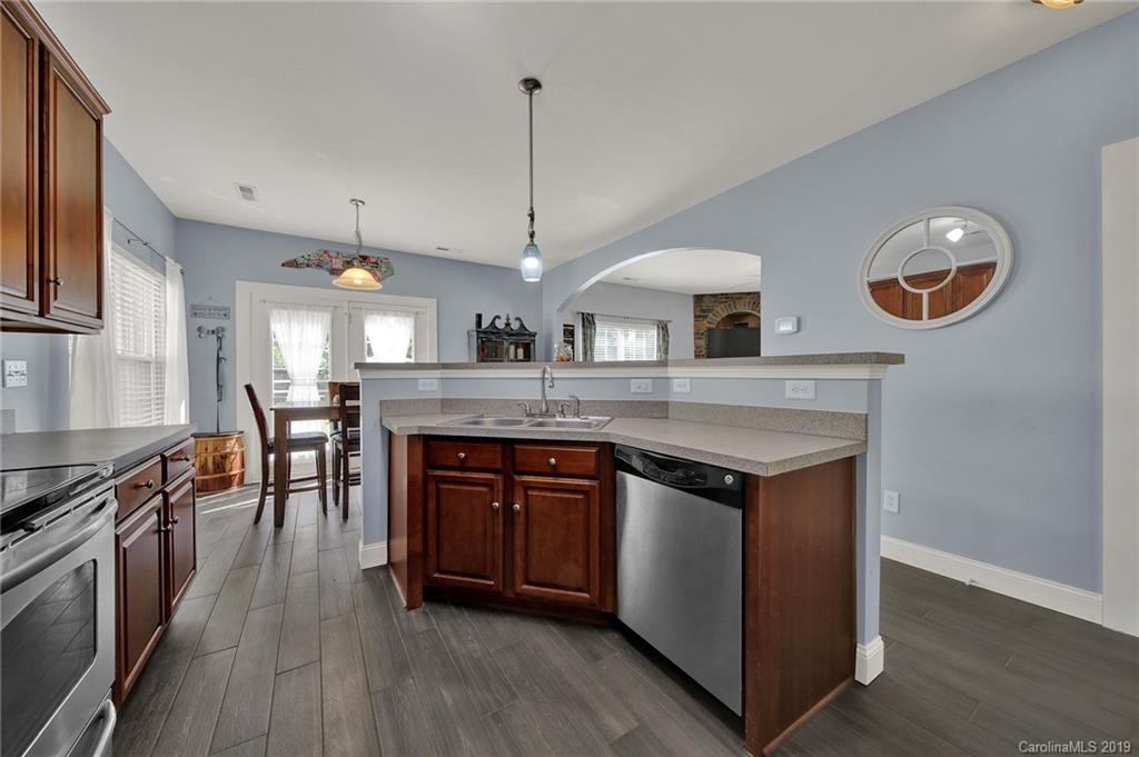 778 Jones Branch Road Fort Mill, SC 29715 - Photo 9 of 44 a kitchen with stainless steel appliances granite countertop wooden cabinets a stove a sink and a wooden floors