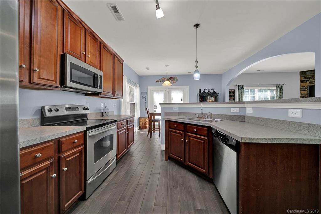 778 Jones Branch Road Fort Mill, SC 29715 - Photo 10 of 44 a large kitchen with stainless steel appliances granite countertop a stove a sink dishwasher and a microwave oven with wooden floor