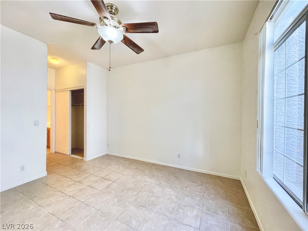 2201 Ramsgate Drive, Unit 915 Henderson, NV 89074 - Photo 27 of 36 A well-lit bedroom features durable tile flooring and a ceiling fan for comfort.