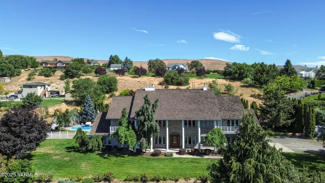 a view of a house with a big yard plants and large trees