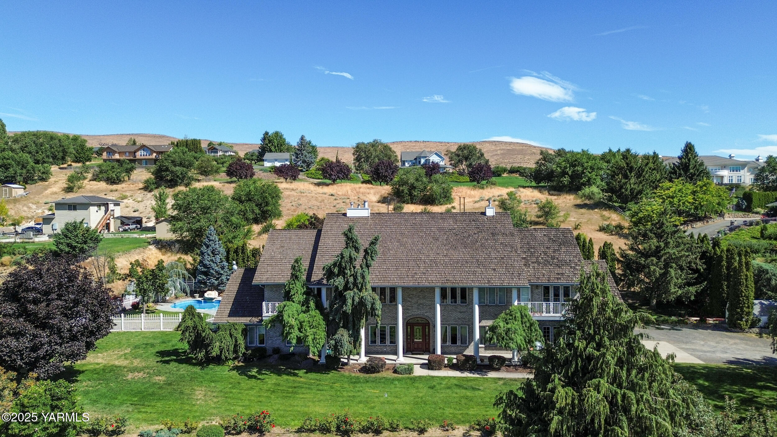 a view of a house with a big yard plants and large trees