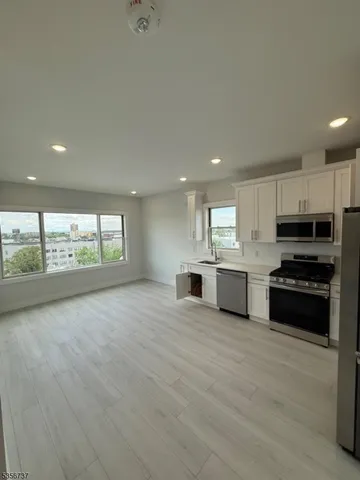 a large kitchen with stainless steel appliances granite countertop a stove a sink and a microwave