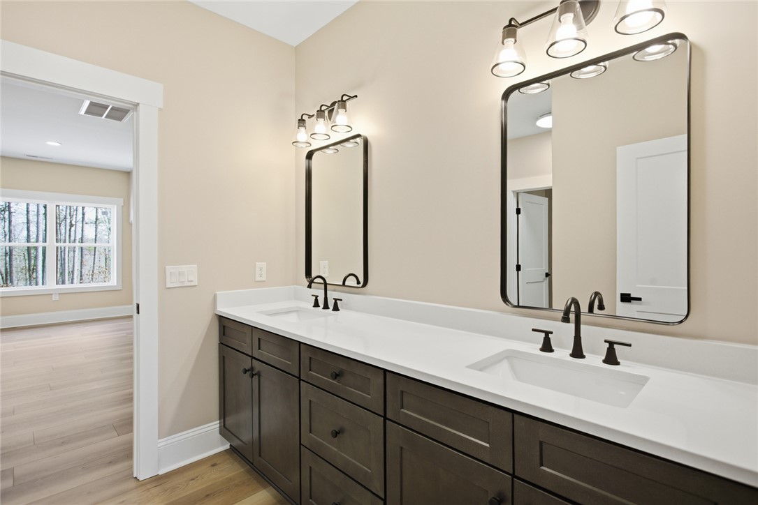 147 McAlister Road West Union, SC 29696 - Photo 29 of 49 This upstairs shared bathroom offers a dual vanity with elegant fixtures, providing ample space and convenience.