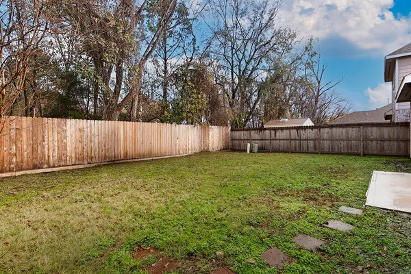 a view of a backyard with wooden fence