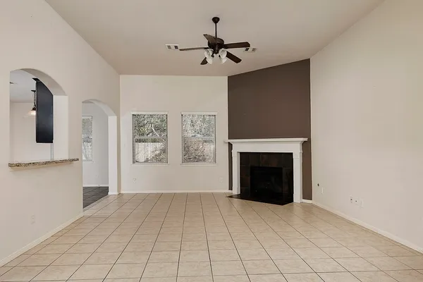 a view of an empty room with a fireplace and a chandelier