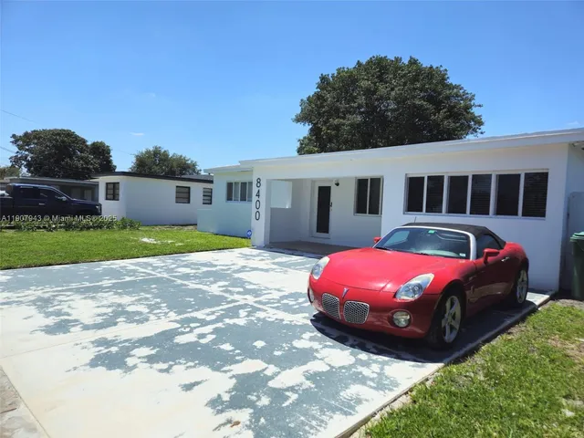a front view of house with yard and car parked