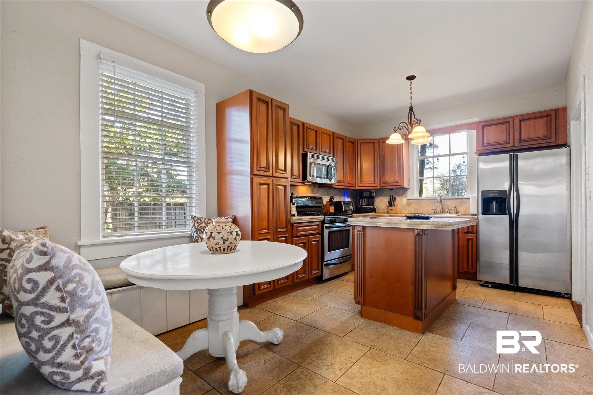 7 Rickarby Place Mobile, AL 36606 - Photo 7 of 20 Kitchen with backsplash, light tile patterned floors, appliances with stainless steel finishes, decorative light fixtures, and a kitchen island