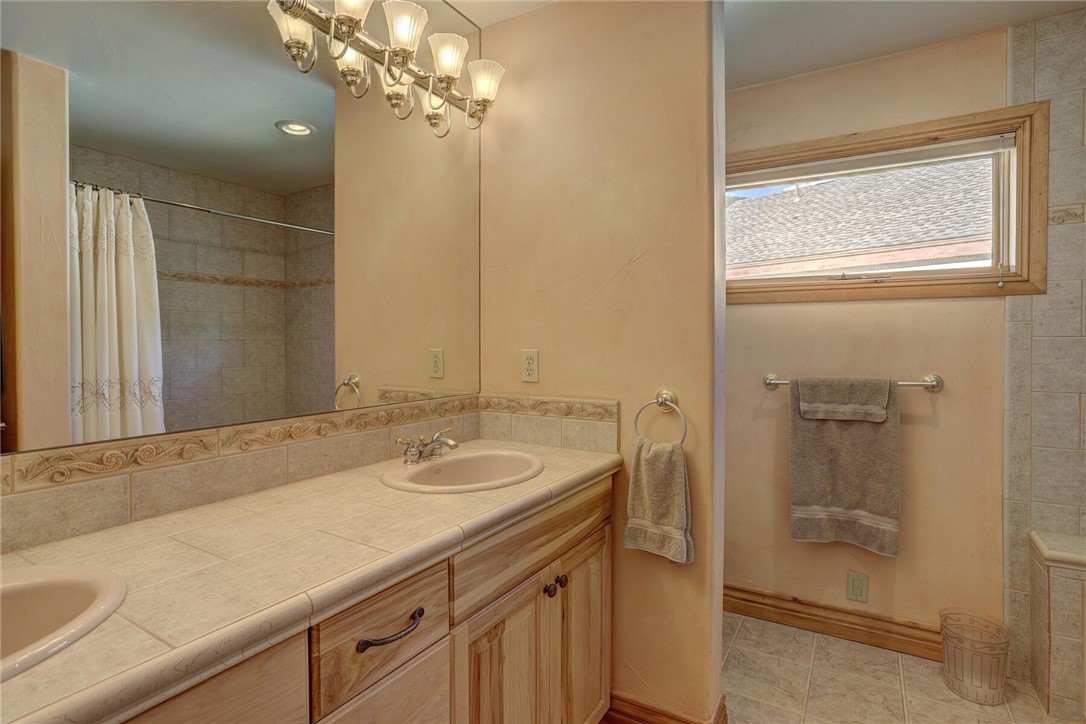 137 Rasor Drive Keystone, CO 80435 - Photo 24 of 35 a bathroom with a granite countertop sink a mirror and a shower