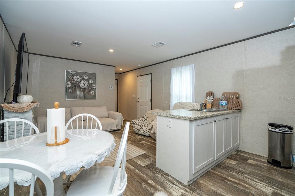 36720 Emeralda Island Road Leesburg, FL 34788 - Photo 12 of 43 a kitchen with stainless steel appliances granite countertop a sink a stove a dining table and chairs