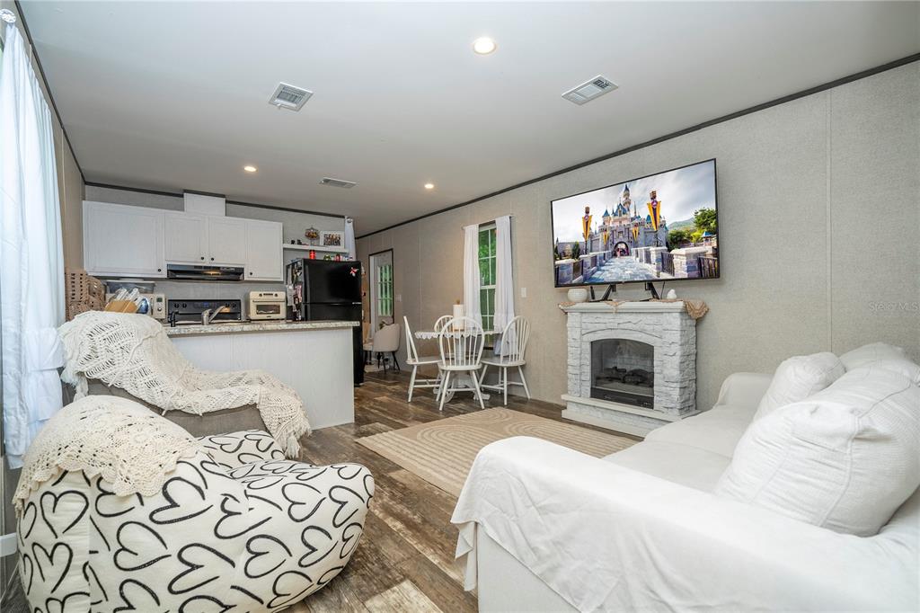 36720 Emeralda Island Road Leesburg, FL 34788 - Photo 13 of 43 a spacious bedroom with a bed and a fireplace