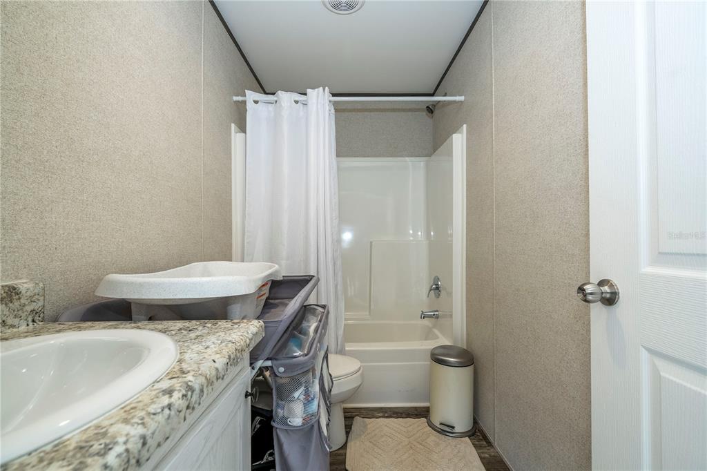 36720 Emeralda Island Road Leesburg, FL 34788 - Photo 18 of 43 a bathroom with a granite countertop sink toilet and shower