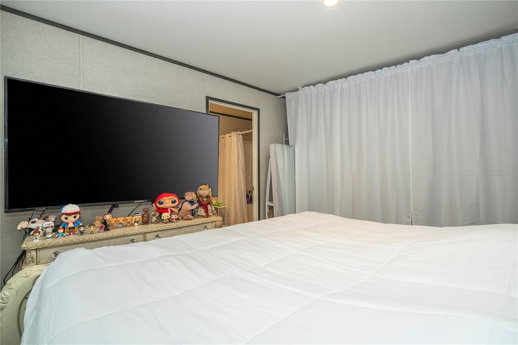 36720 Emeralda Island Road Leesburg, FL 34788 - Photo 21 of 43 a bedroom with bed and a chandelier