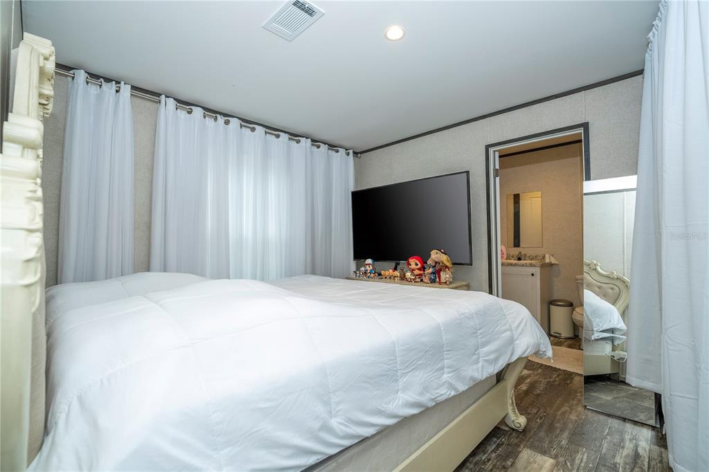 36720 Emeralda Island Road Leesburg, FL 34788 - Photo 22 of 43 a bedroom with a bed and a flat screen tv