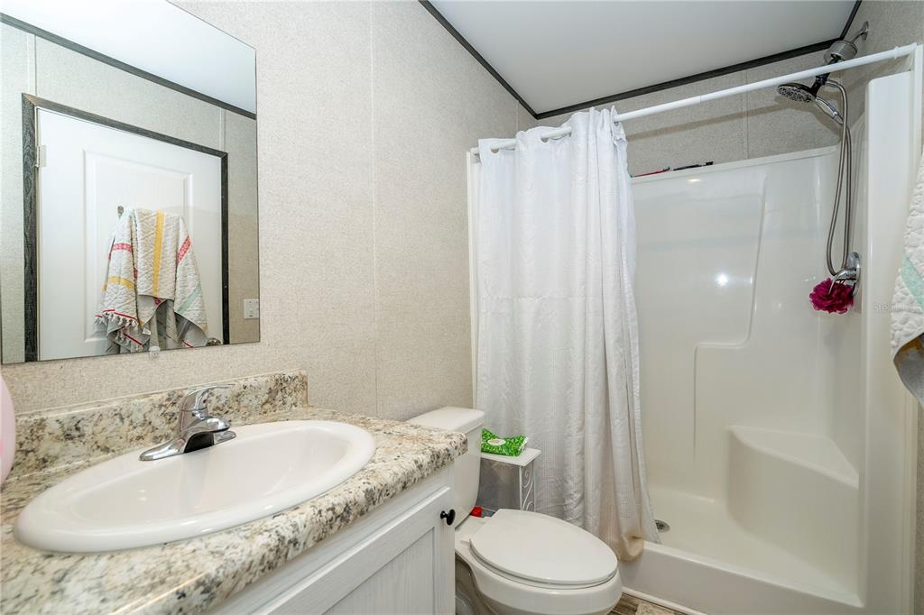 36720 Emeralda Island Road Leesburg, FL 34788 - Photo 24 of 43 a bathroom with a granite countertop sink toilet and shower