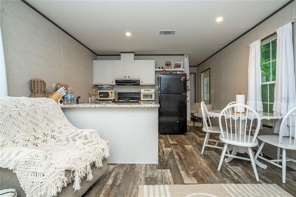 36720 Emeralda Island Road Leesburg, FL 34788 - Photo 27 of 43 a kitchen with kitchen island a appliances a dining table and chairs