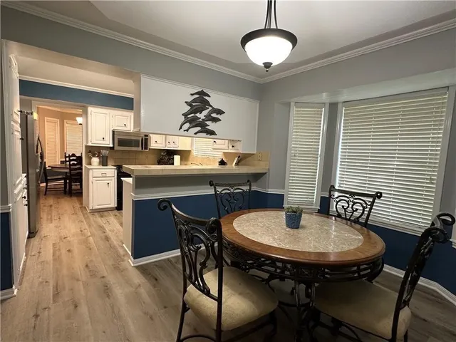 a dining room with furniture a chandelier and wooden floor