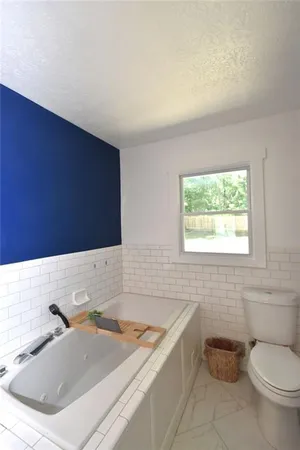a bathroom with a double vanity sink a mirror and bathtub