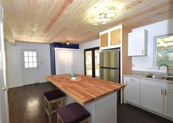 a kitchen with kitchen island a sink dining table and chairs