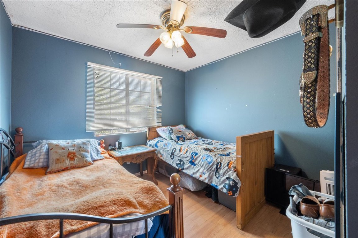 1107 Sturgis Street Taylor, TX 76574 - Photo 11 of 22 a bedroom with two beds and a chandelier