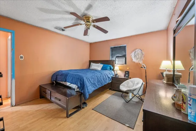 a bedroom with bed and wooden floor