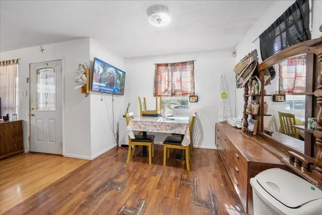 a work room with furniture a large window and wooden floor