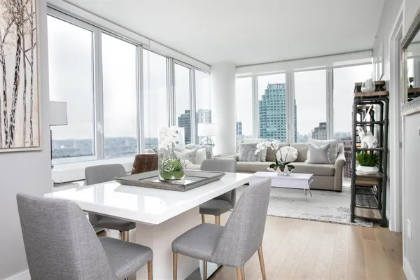 a dining room with furniture a large window and a rug