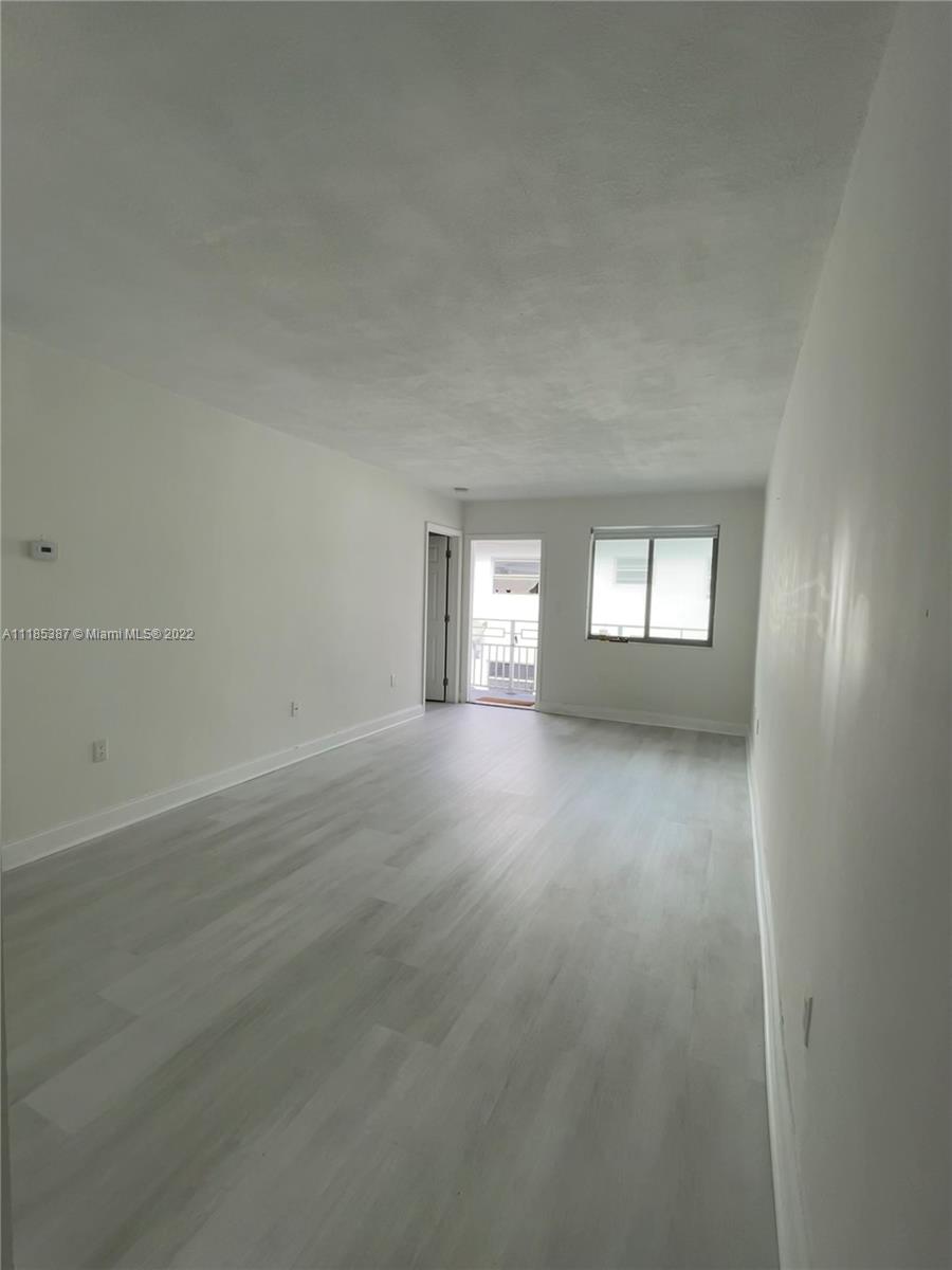 560 Northeast 63rd Street, Unit 3 Miami, FL 33138 - Photo 5 of 16 an empty room with wooden floor and windows