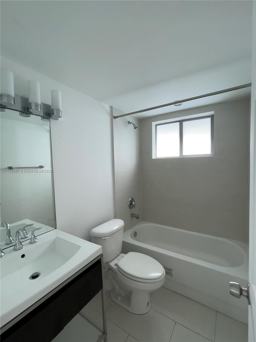 560 Northeast 63rd Street, Unit 3 Miami, FL 33138 - Photo 7 of 16 a bathroom with a sink a toilet and shower