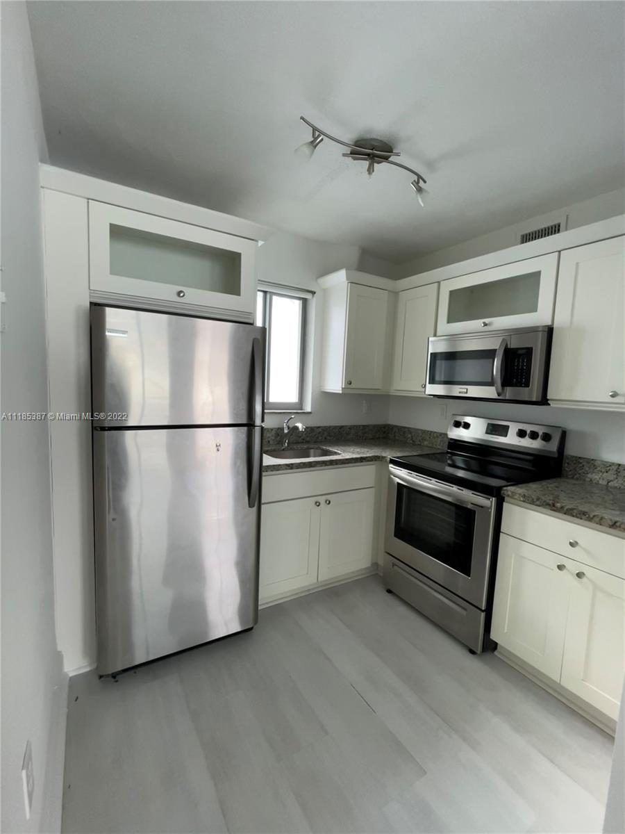 560 Northeast 63rd Street, Unit 3 Miami, FL 33138 - Photo 10 of 16 a kitchen with stainless steel appliances granite countertop a refrigerator a stove a sink and a microwave