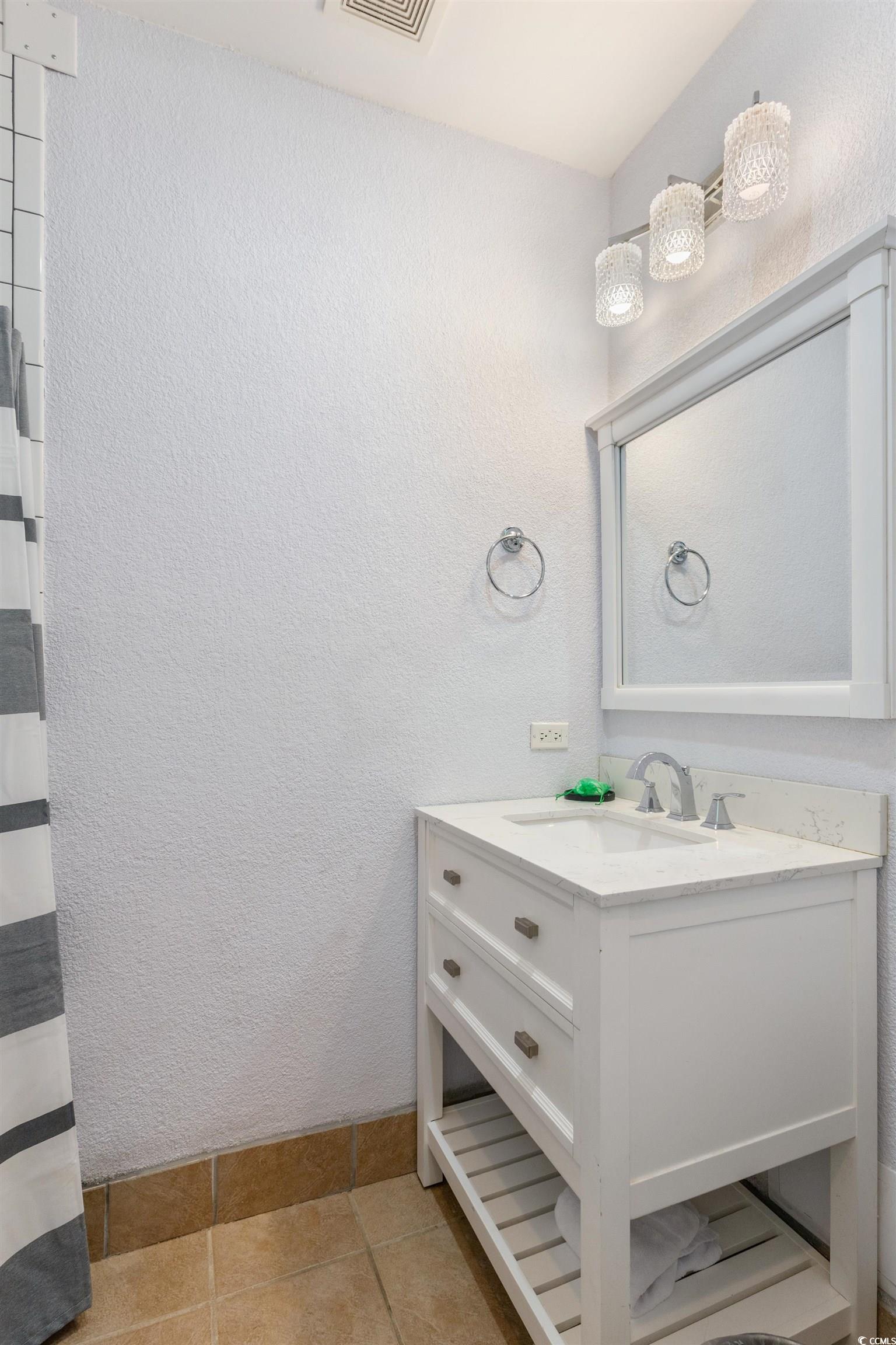 100 Ocean Creek Drive, Unit G14 Myrtle Beach, SC 29572 - Photo 22 of 40 Bathroom with vanity, light tile patterned floors, and a textured wall