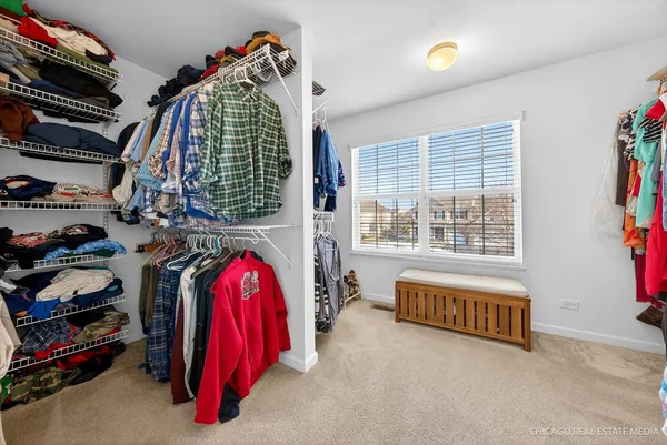 a view of walk in closet with clothes and shoes