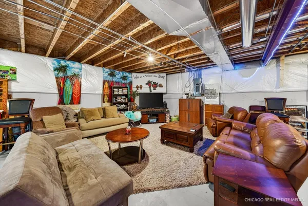 a media room with lots of furniture and a fireplace