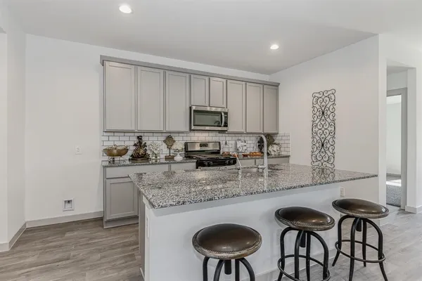 a kitchen with stainless steel appliances granite countertop a stove a sink a microwave and a refrigerator