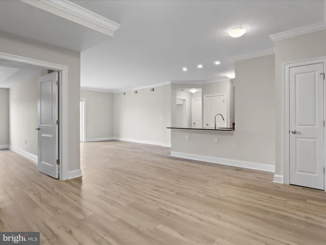wooden floor in an empty room with a kitchen