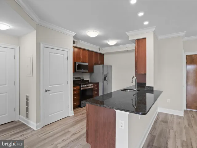 a kitchen with stainless steel appliances granite countertop a sink a stove and a refrigerator